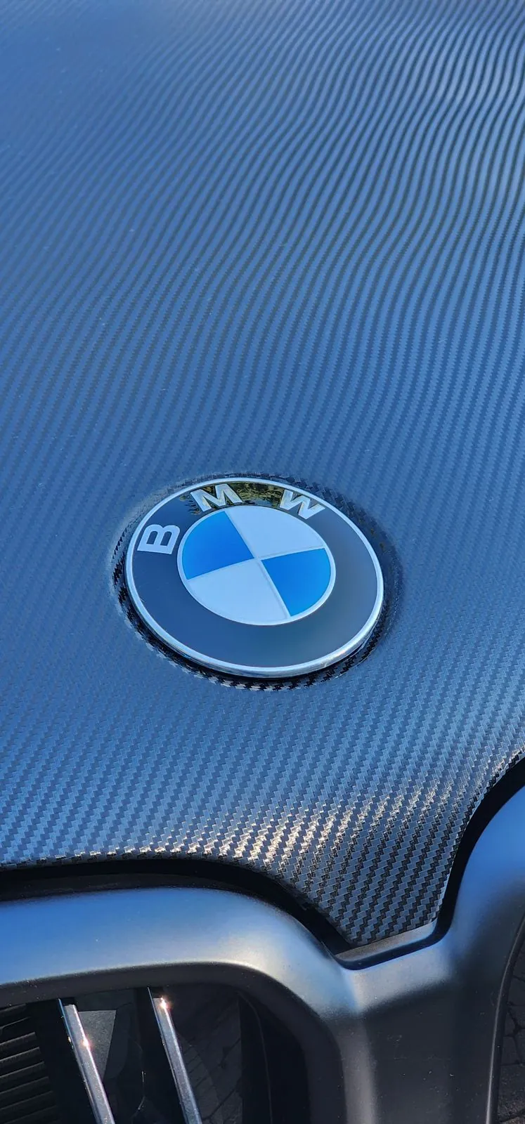 Carbon-look hood wrap detail on a BMW