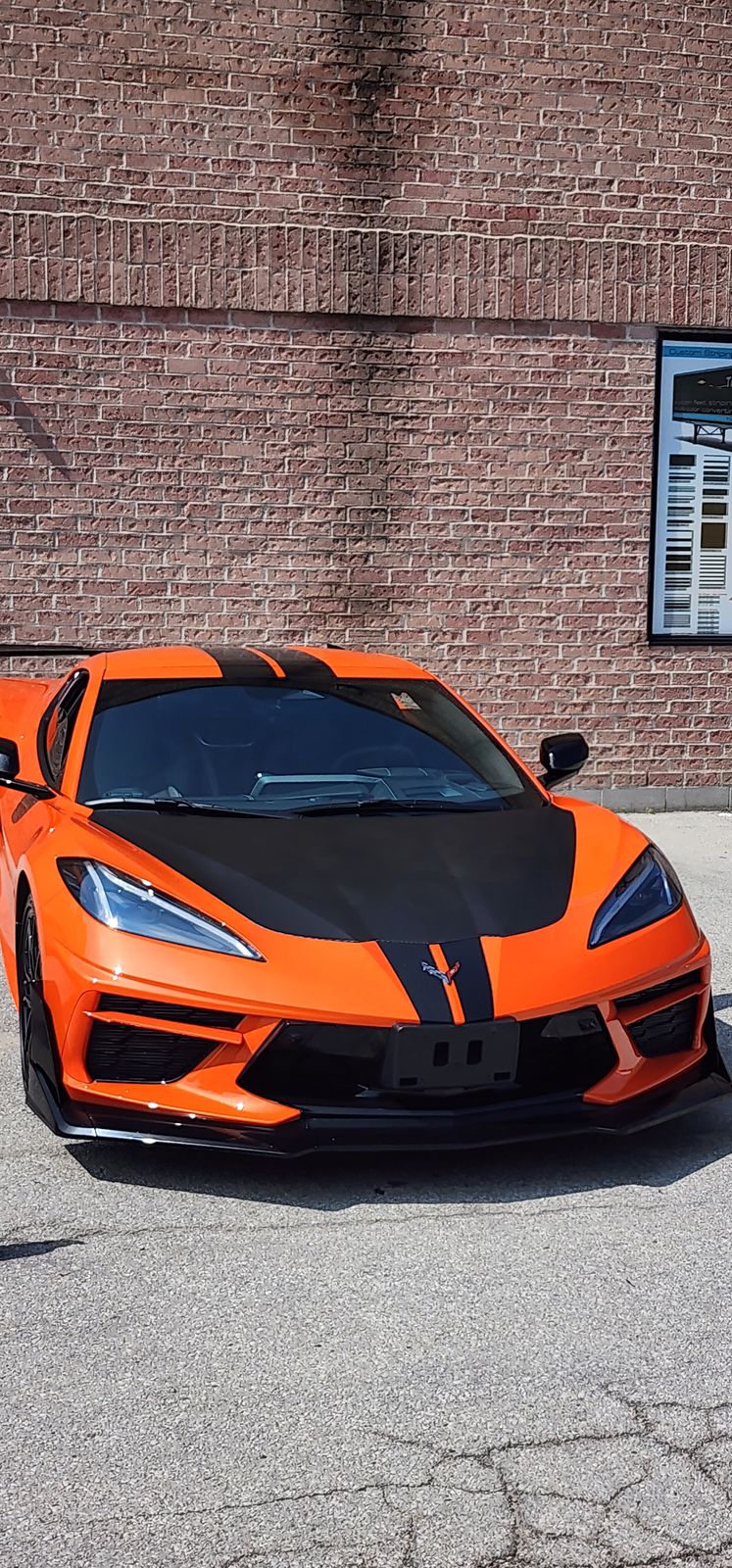 Orange Corvette C8 with black hood and roof wrap