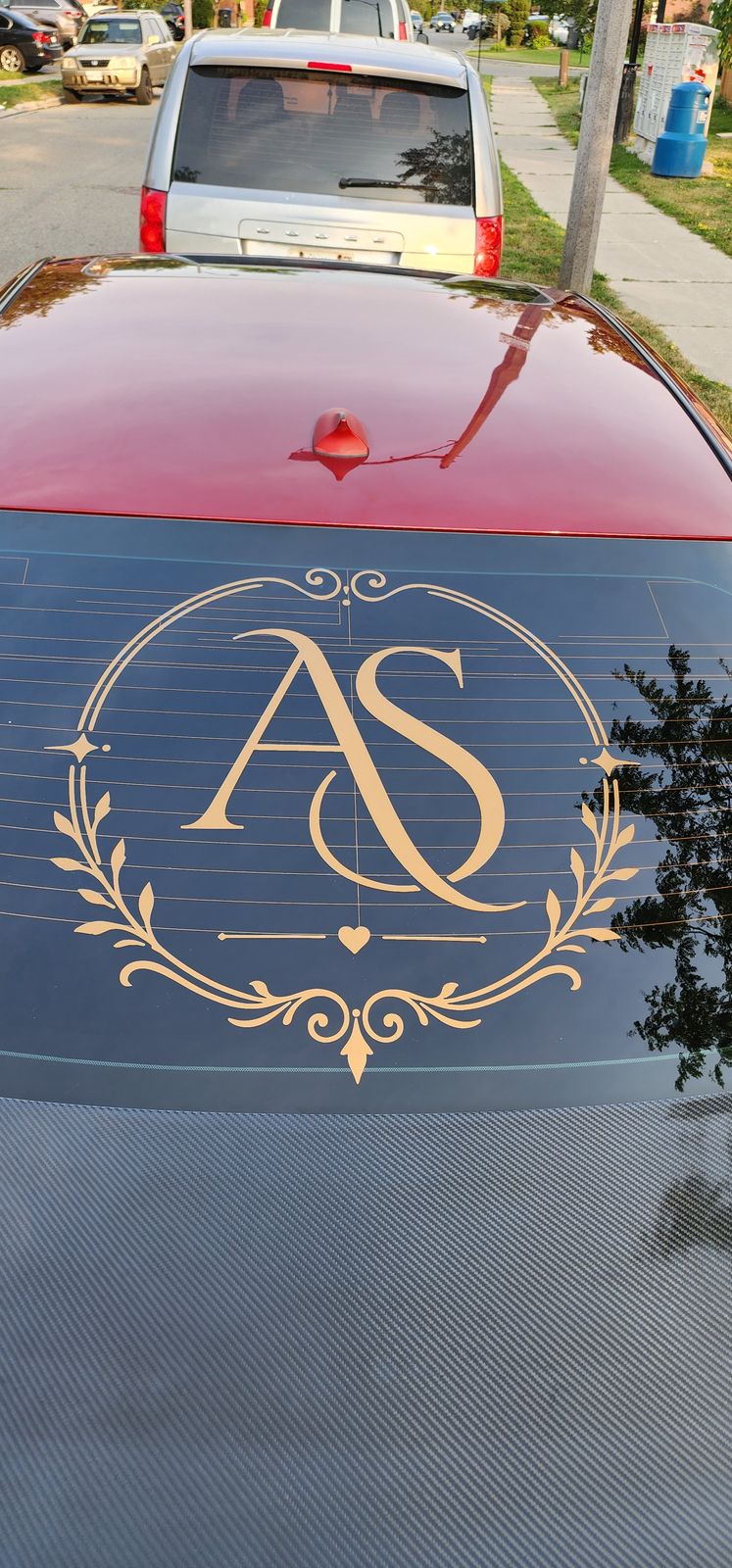 Gold monogram wreath decal on a rear windshield