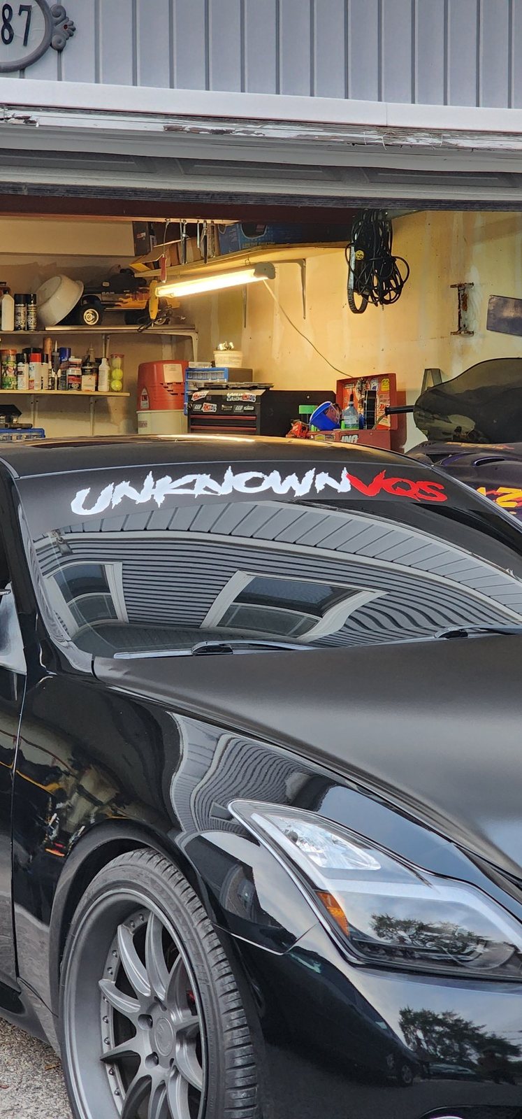 Custom windshield banner being fitted on a car inside a garage